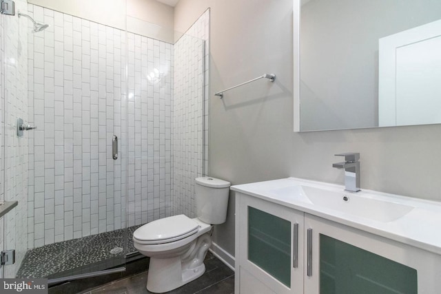 bathroom with vanity, toilet, and a shower with door