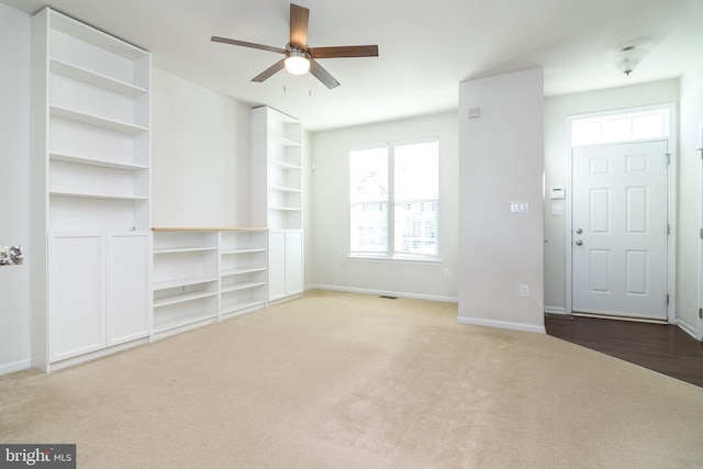 unfurnished living room with carpet flooring, ceiling fan, and plenty of natural light