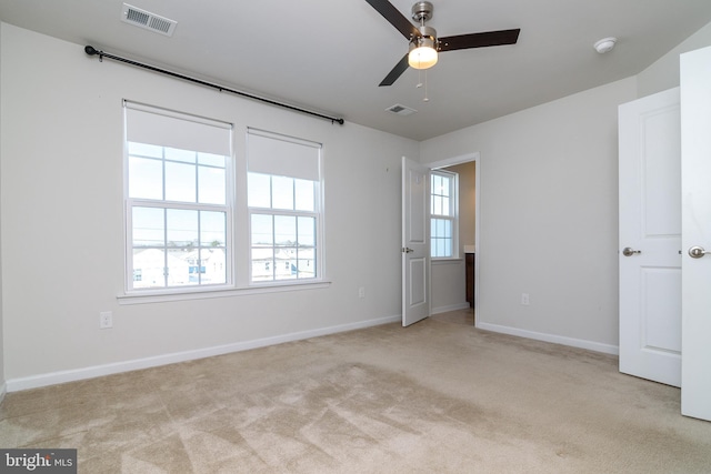 carpeted spare room featuring ceiling fan