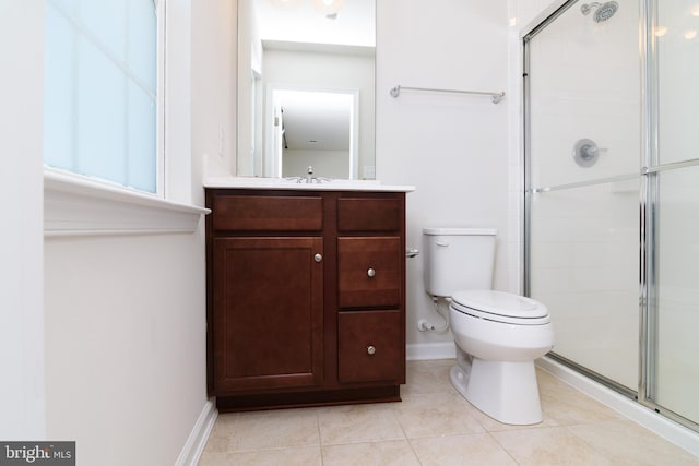 bathroom with toilet, vanity, tile patterned flooring, and walk in shower