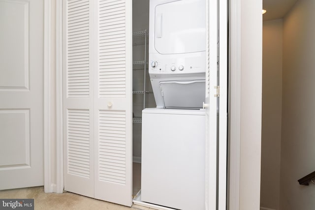 clothes washing area featuring stacked washer / dryer