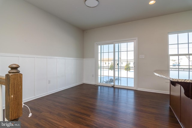 spare room featuring lofted ceiling and dark hardwood / wood-style floors