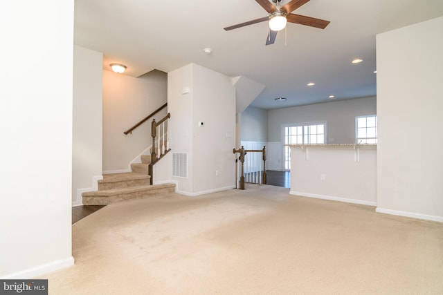 unfurnished living room with ceiling fan and carpet flooring