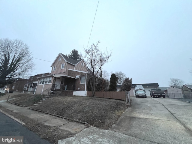 view of front of house with a porch, a garage, and an outbuilding