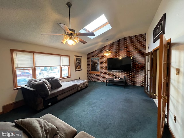 living room with ceiling fan, dark carpet, brick wall, and lofted ceiling with skylight