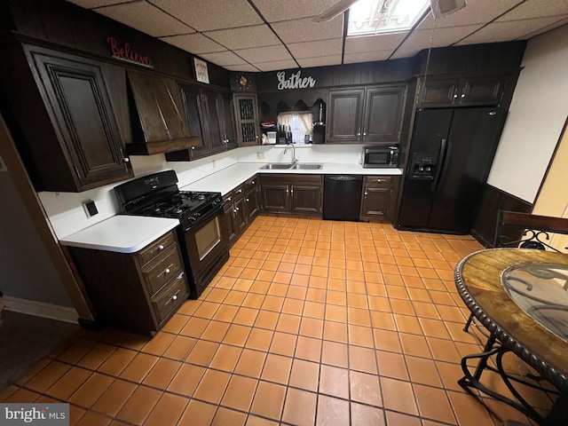 kitchen with black appliances, premium range hood, sink, dark brown cabinetry, and a paneled ceiling