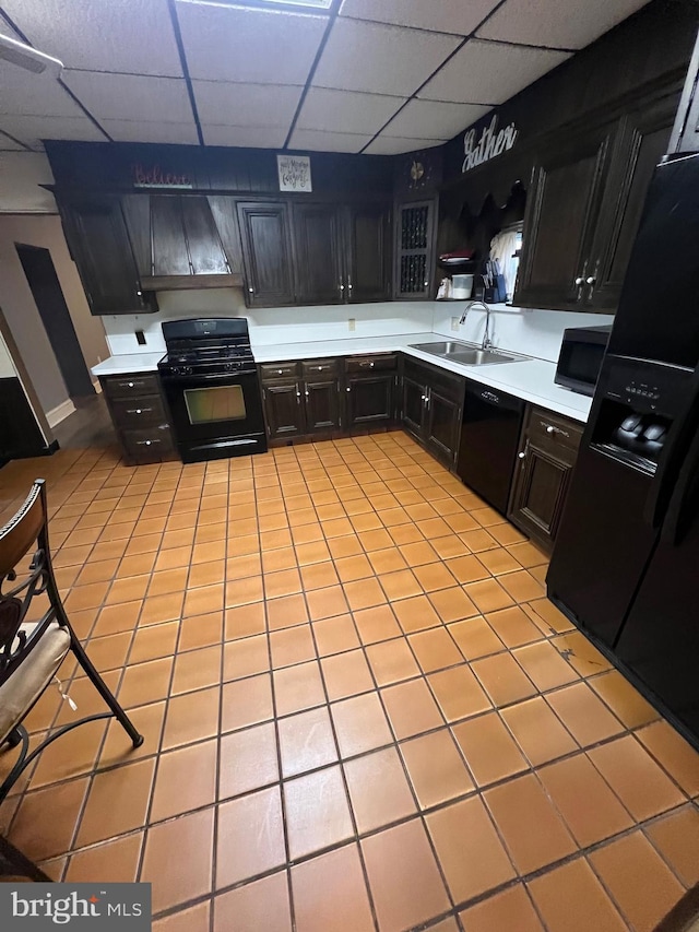 kitchen featuring black appliances, a drop ceiling, light tile patterned flooring, and sink