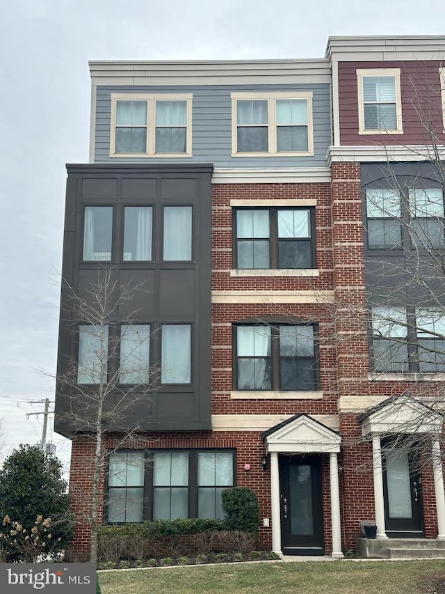 townhome / multi-family property featuring entry steps and brick siding