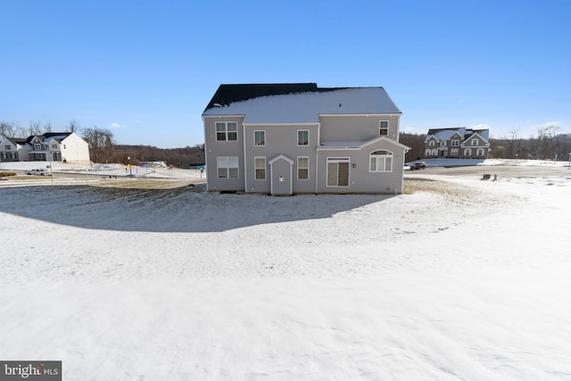 view of snow covered back of property