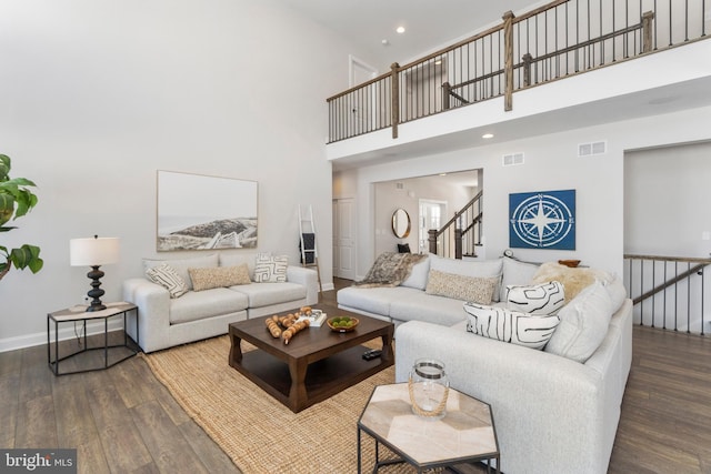 living room featuring dark hardwood / wood-style flooring and a towering ceiling