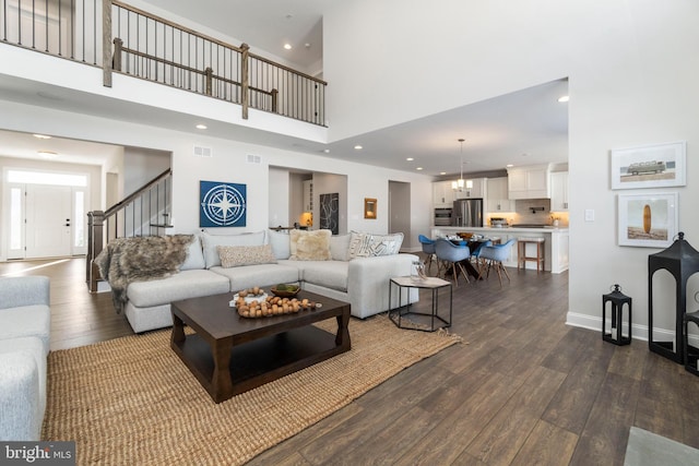 living room featuring a high ceiling and dark wood-type flooring