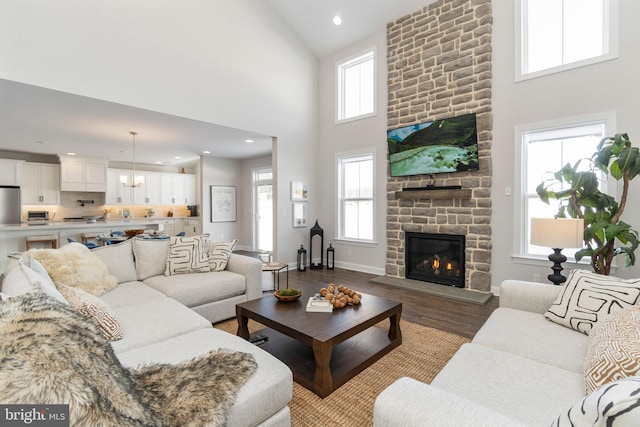 living room featuring a wealth of natural light, a fireplace, and high vaulted ceiling