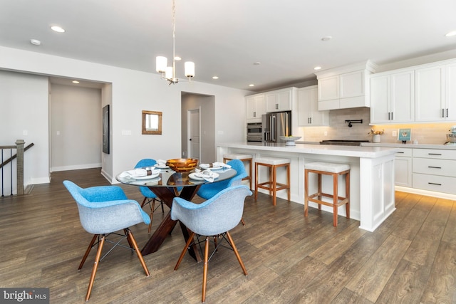 dining space featuring dark hardwood / wood-style flooring and an inviting chandelier