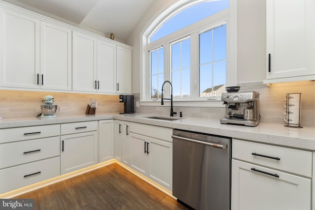 kitchen with tasteful backsplash, dishwasher, white cabinets, and sink