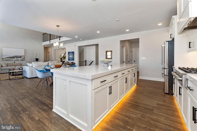 kitchen with dark hardwood / wood-style flooring, decorative light fixtures, white cabinets, a center island, and stainless steel refrigerator