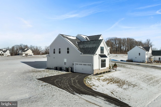 view of side of property with a garage and central air condition unit