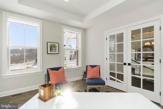 sitting room with a tray ceiling, french doors, and dark wood-type flooring