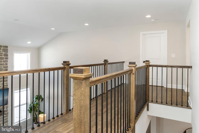 hallway with hardwood / wood-style flooring and vaulted ceiling