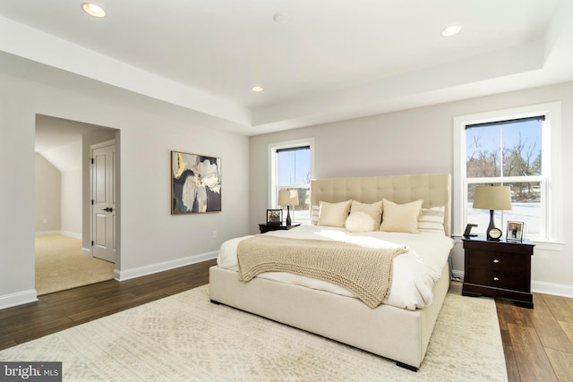 bedroom featuring dark hardwood / wood-style floors and a raised ceiling