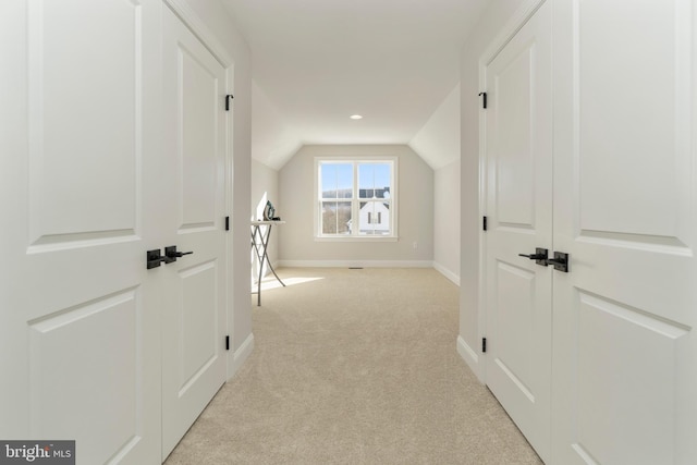 interior space with lofted ceiling and light carpet