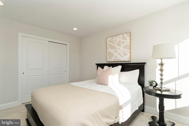 bedroom with light carpet and a closet