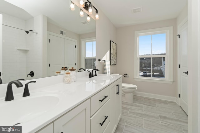 bathroom featuring vanity, a healthy amount of sunlight, and toilet