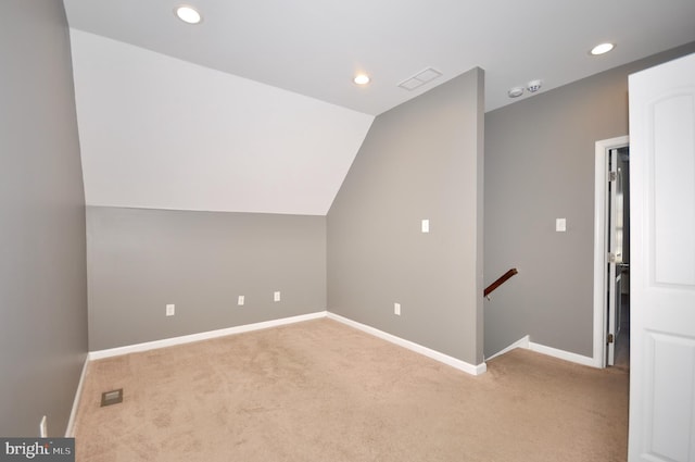 additional living space with lofted ceiling and light carpet