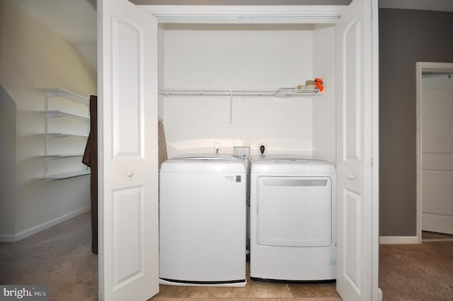 clothes washing area featuring light carpet and washing machine and clothes dryer