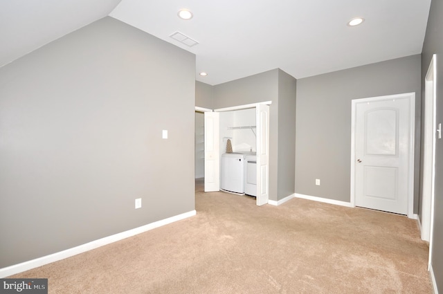 unfurnished bedroom with light colored carpet and separate washer and dryer