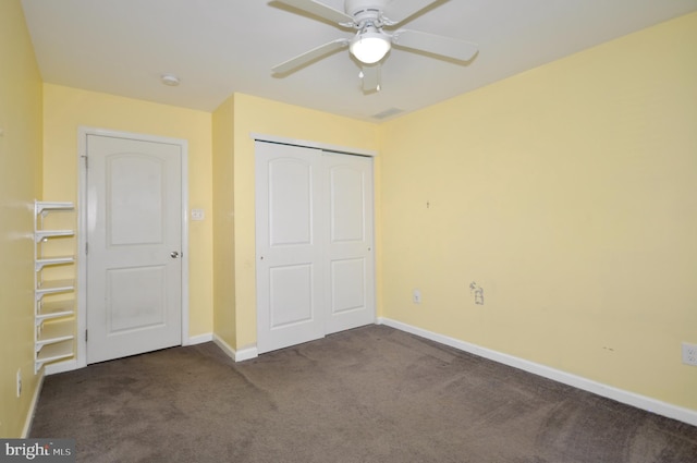 unfurnished bedroom with ceiling fan, a closet, and dark colored carpet