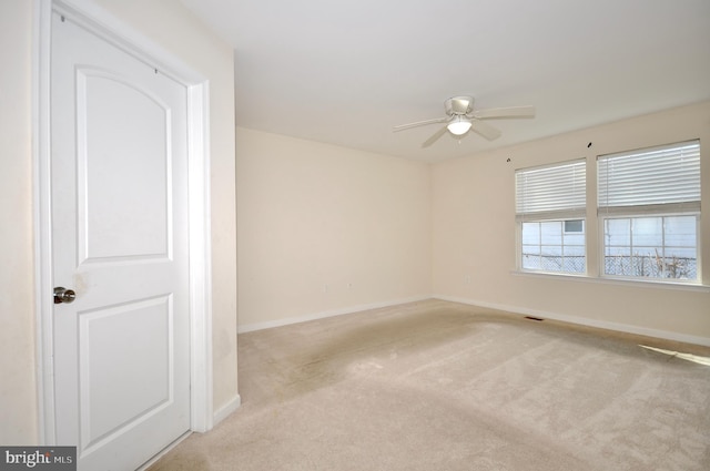 empty room featuring ceiling fan and light carpet