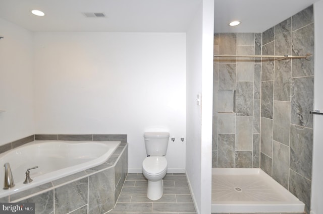 bathroom featuring toilet, independent shower and bath, and tile patterned flooring