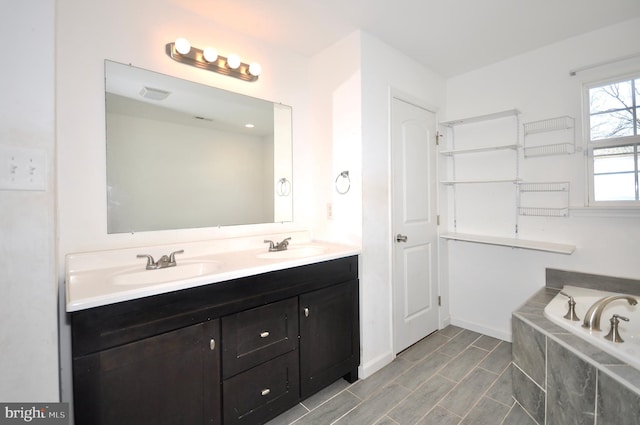 bathroom featuring a relaxing tiled tub and vanity