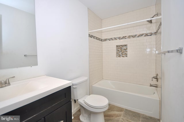 full bathroom featuring toilet, tiled shower / bath, and vanity