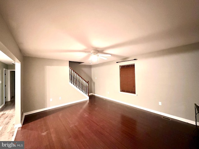 unfurnished room featuring ceiling fan and dark wood-type flooring