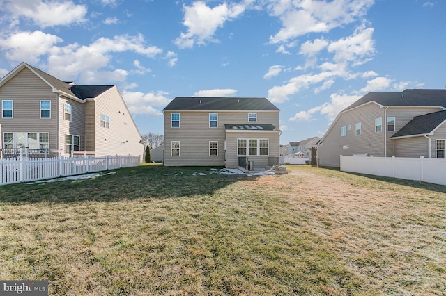 back of house with a yard and fence