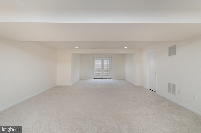 unfurnished room with light carpet, french doors, visible vents, and baseboards