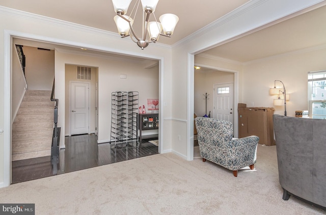 living area featuring carpet floors, visible vents, an inviting chandelier, ornamental molding, and stairs