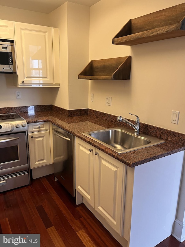 kitchen featuring dark hardwood / wood-style flooring, sink, stainless steel appliances, and white cabinets