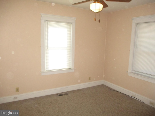 carpeted spare room with ceiling fan