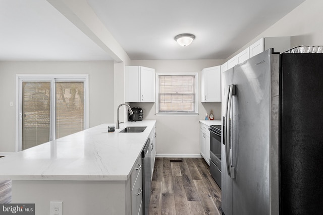 kitchen featuring stainless steel appliances, white cabinetry, a healthy amount of sunlight, and sink