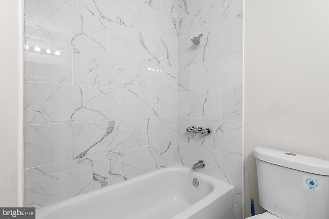 bathroom with toilet and tiled shower / bath