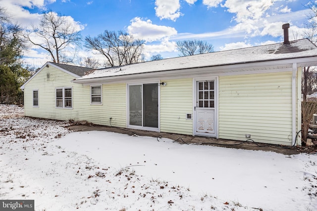 view of snow covered back of property