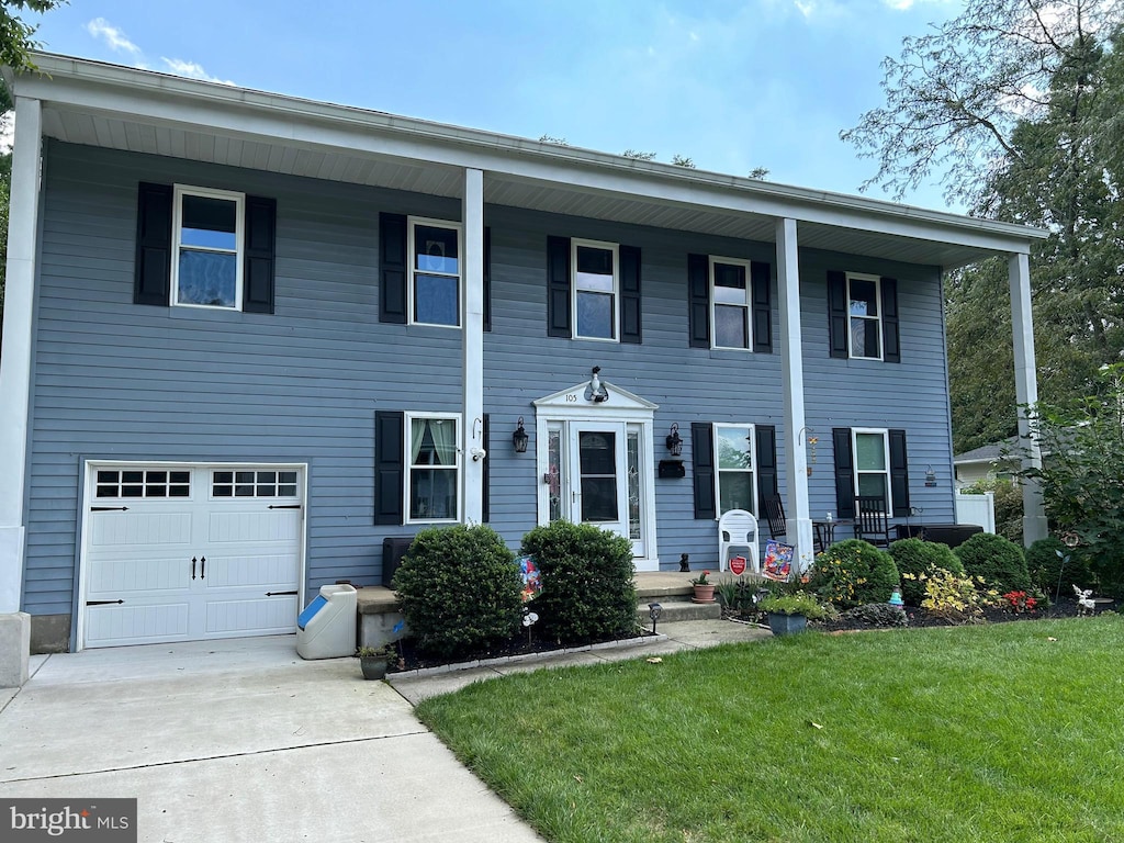 view of front of property with a front yard and a garage