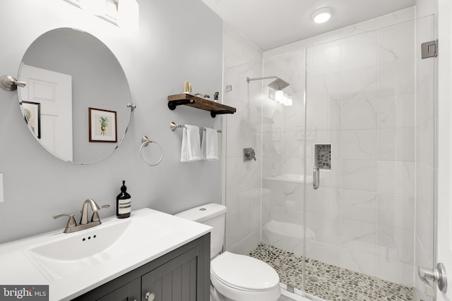 bathroom with an enclosed shower, vanity, and toilet