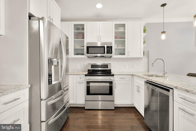 kitchen featuring pendant lighting, sink, white cabinetry, decorative backsplash, and stainless steel appliances