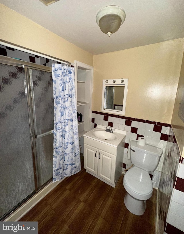 bathroom featuring wood-type flooring, toilet, vanity, tile walls, and a shower with shower curtain