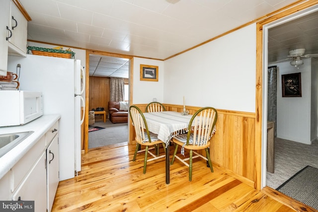 dining room with wooden walls and light hardwood / wood-style floors