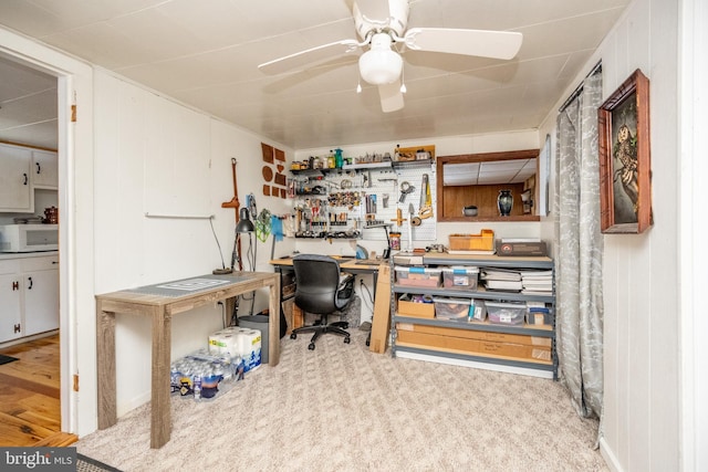 home office featuring ceiling fan, carpet, and a workshop area