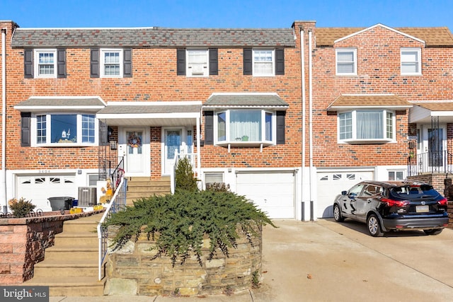 view of property featuring central air condition unit and a garage